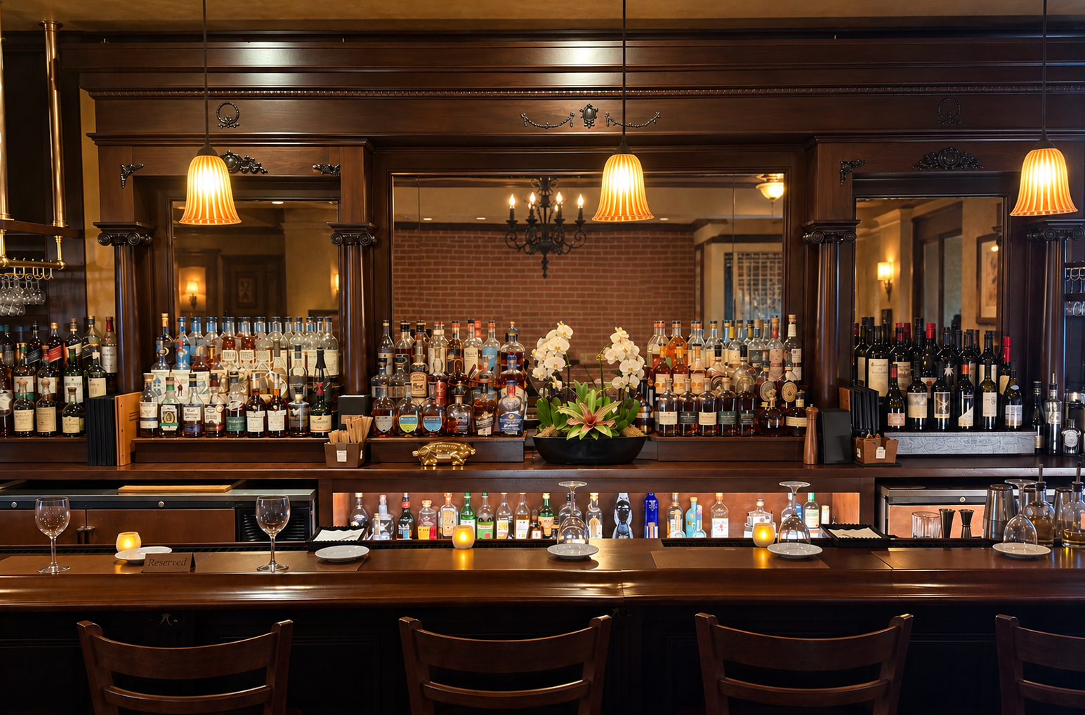 The Newbury Park bar with dark wood, mirrors, and shelves of wine and spirits